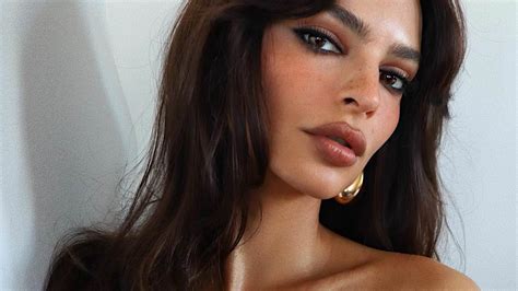 emily ratajkowski pulls down her tank top so low she has to use her hand to cover one of her