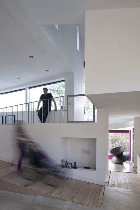 A Blurry Photo Of People Walking Up And Down Stairs In A House With