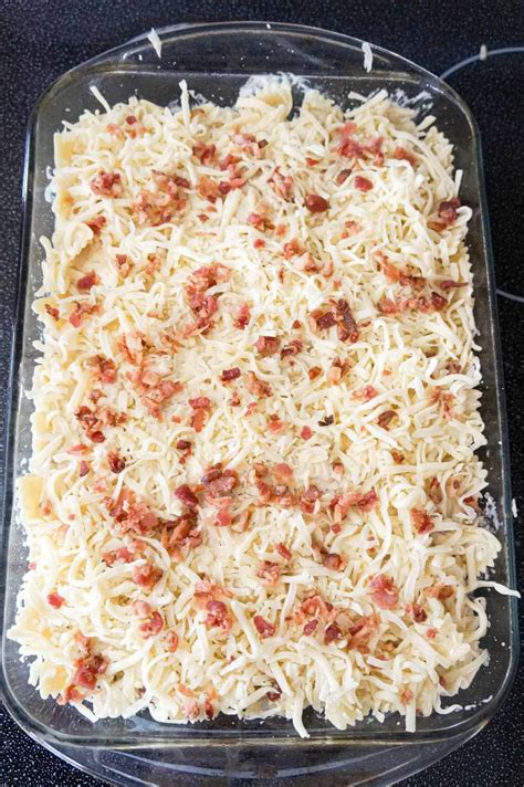 Crumbled Bacon And Shredded Mozzarella Cheese On Top Of Alfredo Pasta