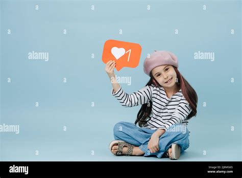 Smiling Tween Girl In French Beret Holding Like Message Symbol She Is Sitting On The Floor