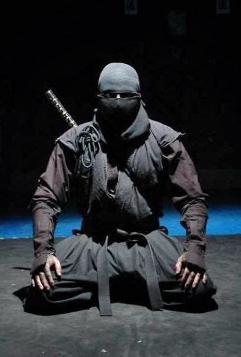 A Man Sitting On The Ground With Two Swords In His Hands