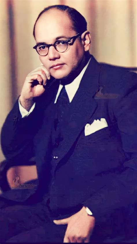 A Man In A Suit And Tie Sitting Down With His Chin Resting On His Hand