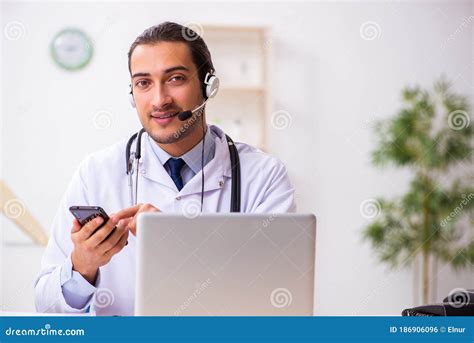 Young Doctor Listening To Patient During Telemedicine Session Stock
