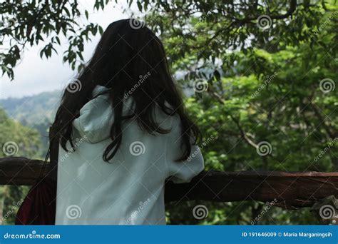 A Girl Standing Alone In The Wood From The Back Looking At The Forest