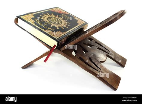 Quran With Quran Wooden Stand In Front Of White Background Stock Photo