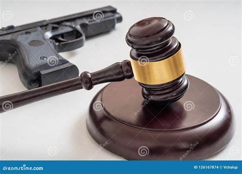 Gavel In Front Of A Pistol Gun Laws And Legislation Concept Stock