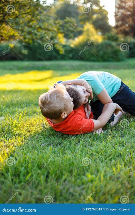 Two Friends Play Rolling On The Grass Spending Time Together Happily