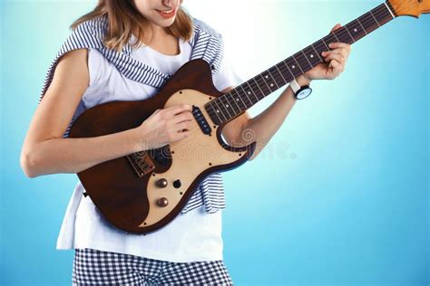 Young Woman Playing Electric Guitar On Color Background Stock Photo
