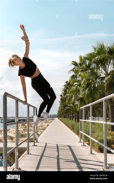 Carefree Woman Athlete Jumping During Her Fitness Workout Outdoors