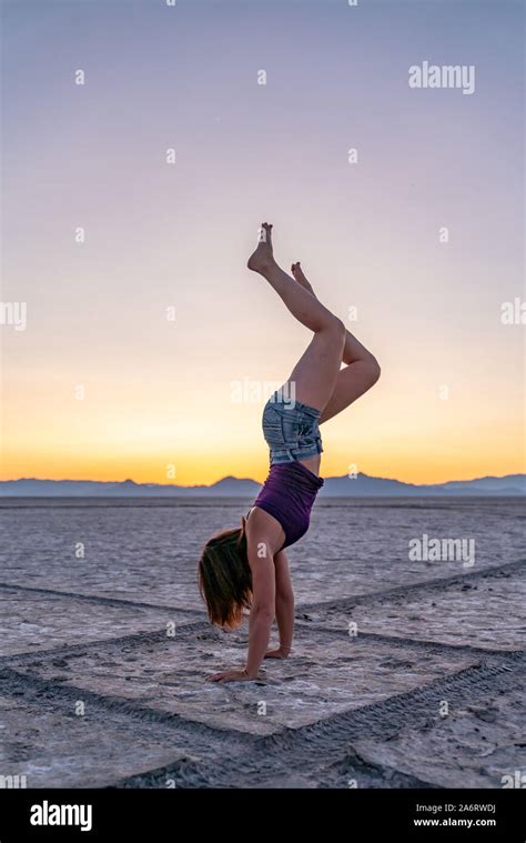 Beautiful Woman Doing Handstands During Sunset In Bonneville Salt Flats