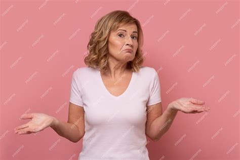 premium photo clueless mature woman shrugging helpless with her shoulders