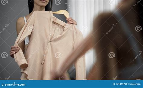Ładna Kobieta Próbuje Bluzkę Przed Lustrem W Garderobie Przygotowywa Dla Daty Obraz Stock
