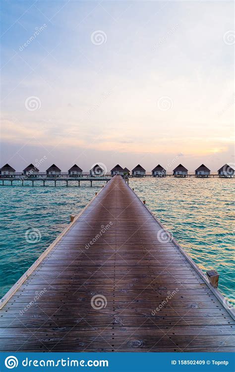 Beautiful Tropical Sunset Over Maldives Island With Water Bungalow In