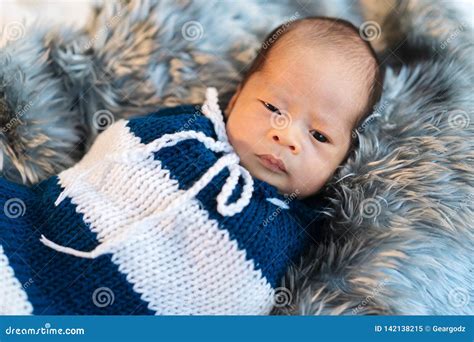 Newborn Baby Boy Swaddled In A Knit Wrap On Fur Bed Stock Image Image