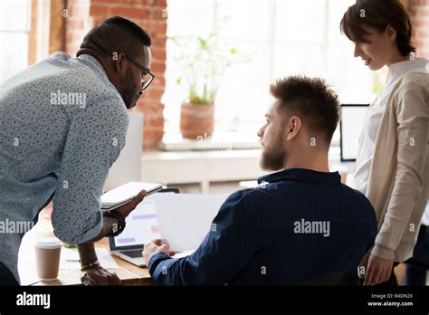 African American Worker Trainee Consulting With Colleague Stock Photo