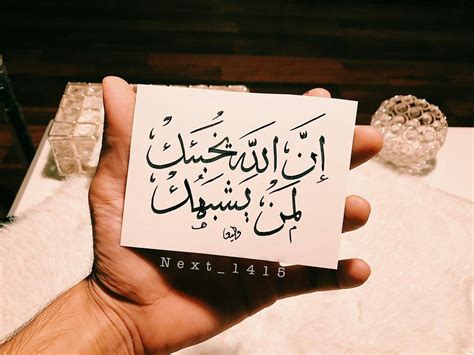 A Person Holding Up A Piece Of Paper With Arabic Writing On It