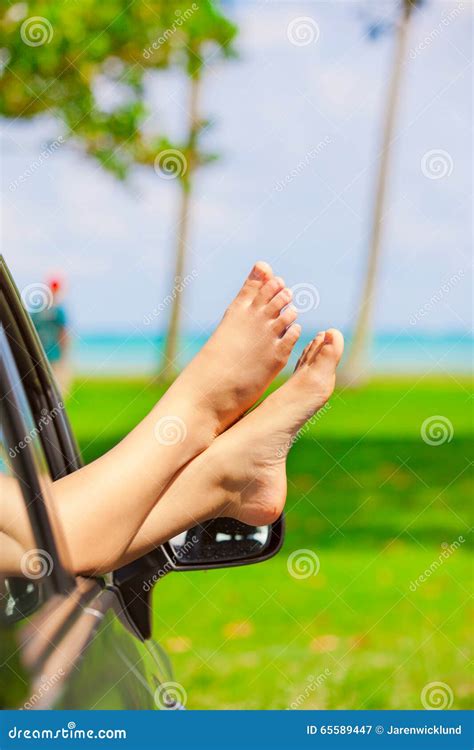 Bare Feet Of Female Sticking Out Car Window By Ocean Royalty Free