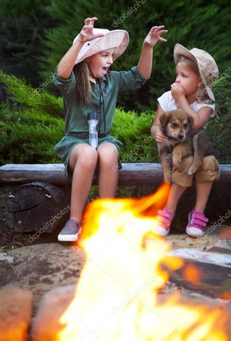 Two Sisters Talking Stories By The Campfire — Stock Photo © Dasha11