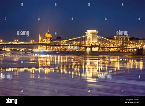 Szechenyi Chain Bridge Reflected In Danube River Water With Floating