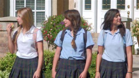 Three Pretty Uniformed Teen School Girls Standing At A Curb Stock