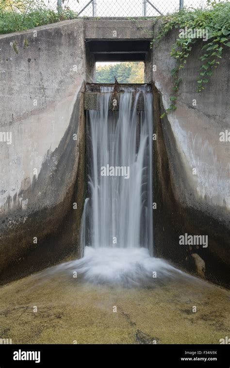Waters Streams Over The Spillway Of A Small Concrete Dam That Blocks