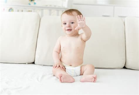 Premium Photo Smiling Baby Boy In Diapers Sitting On Bed