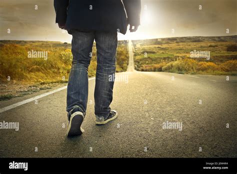 Lonely Man Walking On Road Stock Photo Alamy