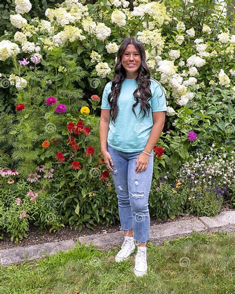 Amerasian Teenage Girl Posing In Front Of A Beautiful Bed Of Flowers In
