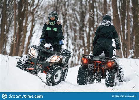Riding The Opposite Ways Two People Are On The Atv In The Winter