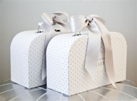 Two White Boxes With Bows On Them Sitting On A Table Next To Another