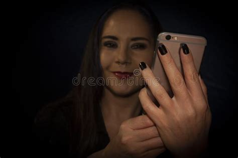 Female Hands Manipulating Mobile Phone To Take Selfie Of Her Face With