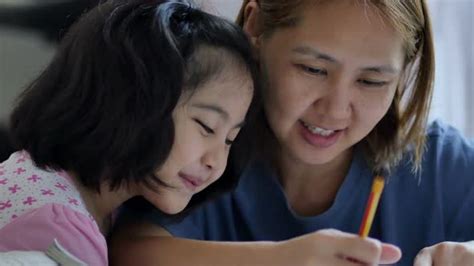 Close Up Shot Little Asian Girl With Mother Doing Homework In The Bed Room Stock Footage