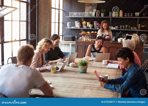 Interior Of Coffee Shop With Customers Using Digital Devices Stock