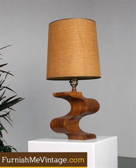 The conical lamp body is further accentuated with a turned wood neck. Mid Century Modern Solid Wood Carved Lamp