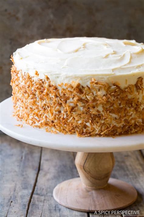 Hands pouring cream from pastry bag on carrot pie. The Best Carrot Cake Recipe - A Spicy Perspective