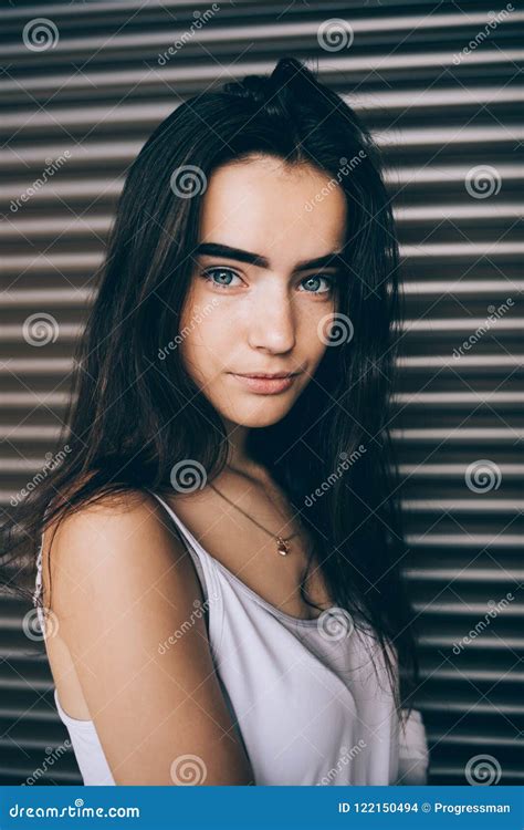 Portrait Of Cute Girl With Long Dark Hair And Blue Eyes Stock Photo