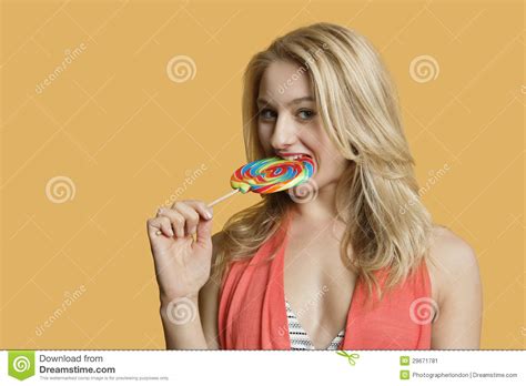Portret Van Een Mooie Blonde Vrouw Die Lolly Over Gekleurde Achtergrond