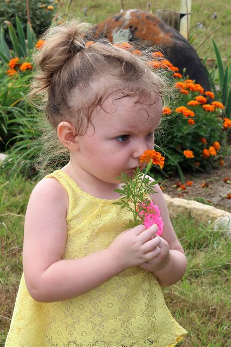 Little Girl Smelling Orange Flower Free Stock Photo