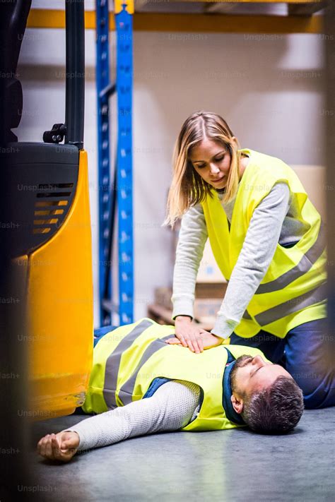 An Accident In A Warehouse Woman Performing Cardiopulmonary Resuscitation Photo Aids Image