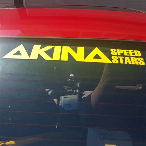 The Sticker On The Back Of A Red Car Reads Akna Speed Stars