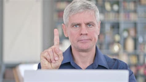 Portrait Of Handsome Middle Aged Man Saying No By Finger Sign Stock