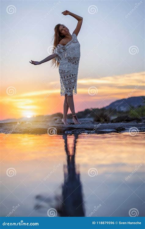 Woman Dances In Front Of The Sunset At The Seaside Stock Photo Image Of Female Dress