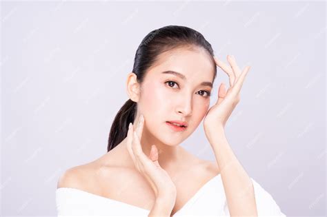 hermosa joven asiática con cara de piel blanca limpia y fresca en pose de belleza tocando el