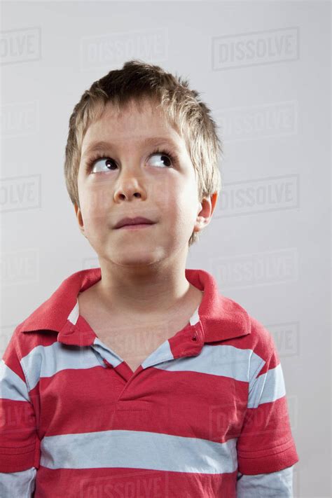 A Young Boy Looking Up And To The Side Studio Shot Stock Photo