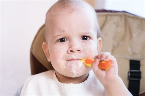 Baby Holding A Spoon In His Mouth Stock Photo Image Of Child Lunch