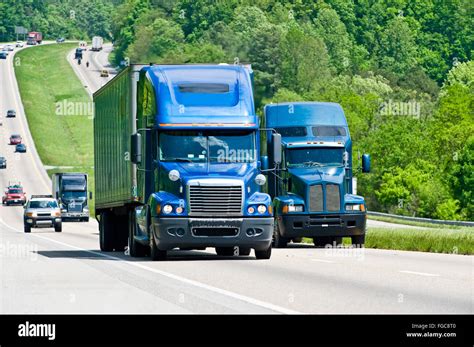 Two Blue Semi Trucks Climb Hill On Interstate Highway In Tennessee