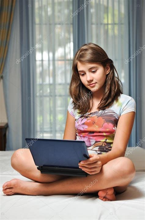 Joven adolescente chica acostada en su cama navegar por Internet fotografía de stock
