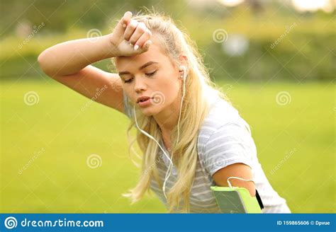 tired female runner in the park taking a break sporty woman breathing and resting after