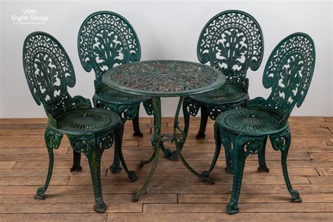 Table 35 w x 27 d x 27.5 h chair 22 w x 21 d x 39.25 a set of wrought iron outdoor furniture consisting of a table, two armchairs and four side chairs. Green cast iron garden table and chairs