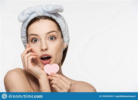 Girl Holding Heart Shaped Cosmetic Sponge While Looking At Camera